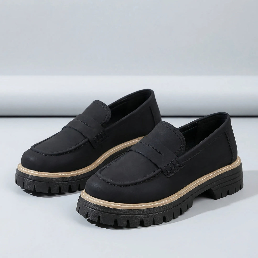 Sidovy av bekväma damslippers Paige med stabil låg blockklack och elegant siluett, perfekta slip-on.