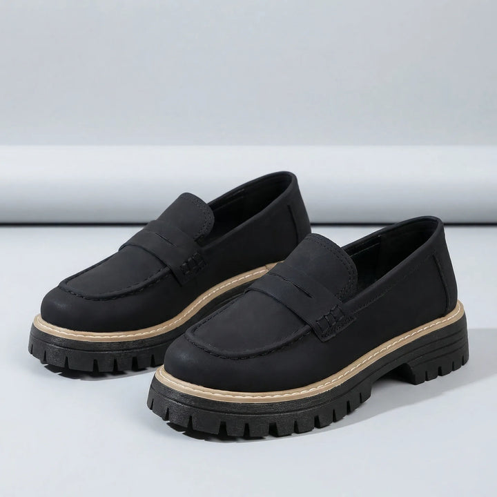 Sidovy av bekväma damslippers Paige med stabil låg blockklack och elegant siluett, perfekta slip-on.