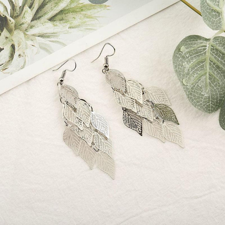 Eleganta färgglada örhängen med lövmönster i grönt, lila, guld, silver och svart; en perfekt accessoar för din stil.