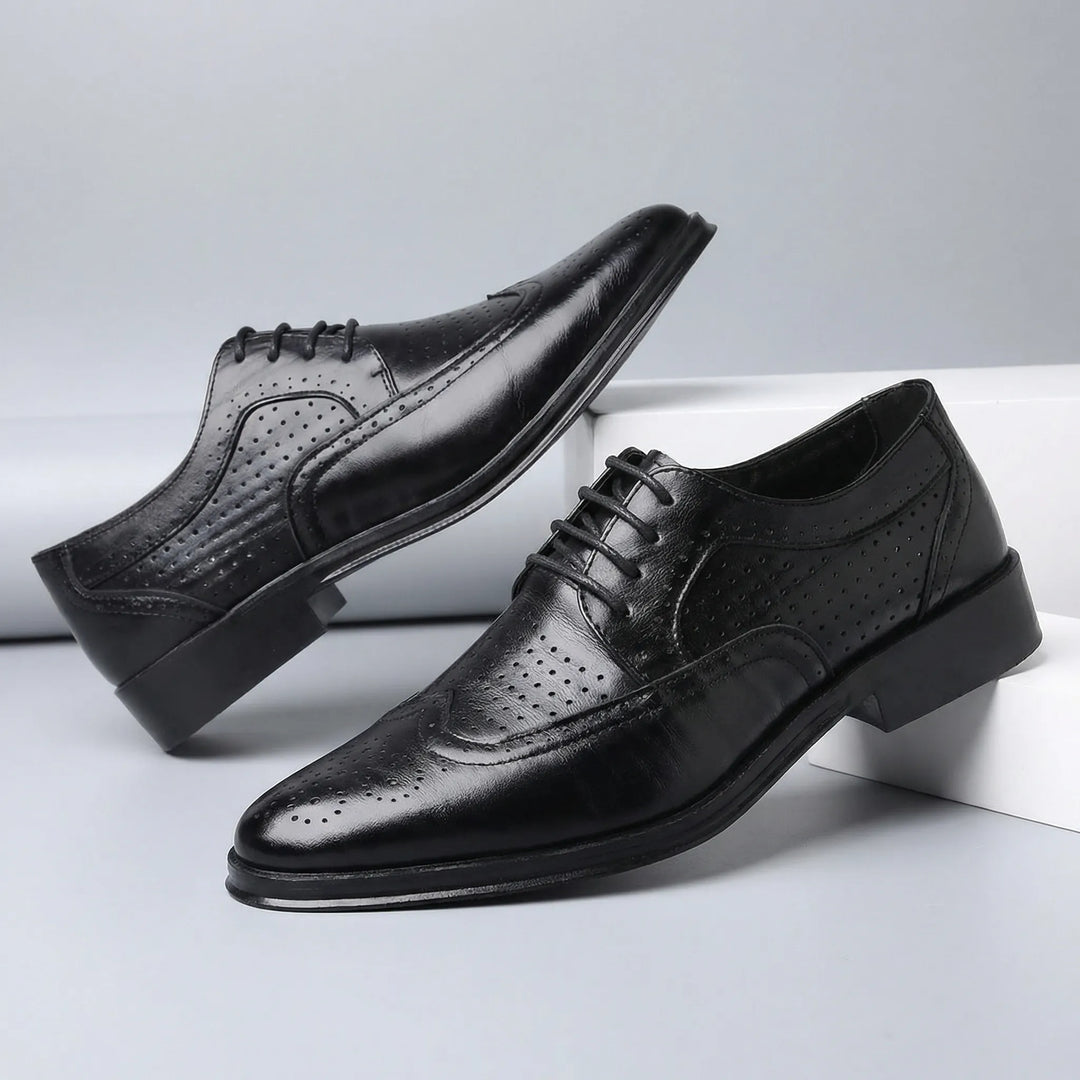 Detaljbild av elegant wingtip brogue-mönster på herr snörskor. Klassisk formell stil, hög kvalitet.
