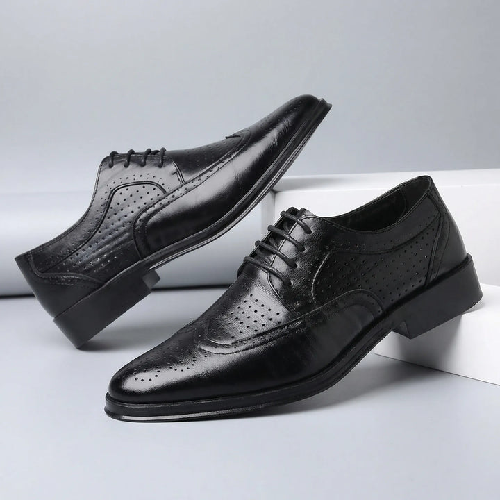 Detaljbild av elegant wingtip brogue-mönster på herr snörskor. Klassisk formell stil, hög kvalitet.