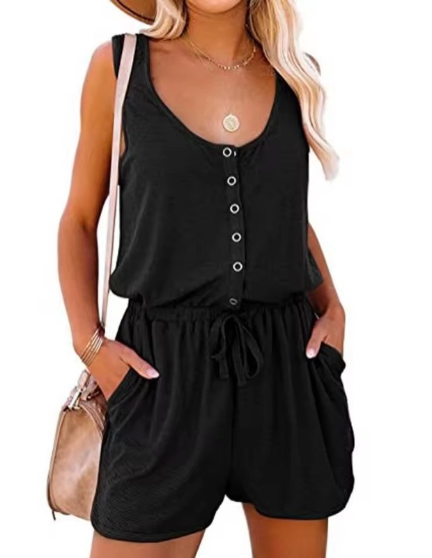 En kvinna bär en stilren ärmlös kort jumpsuit med knappstängning, perfekt för sommaren.