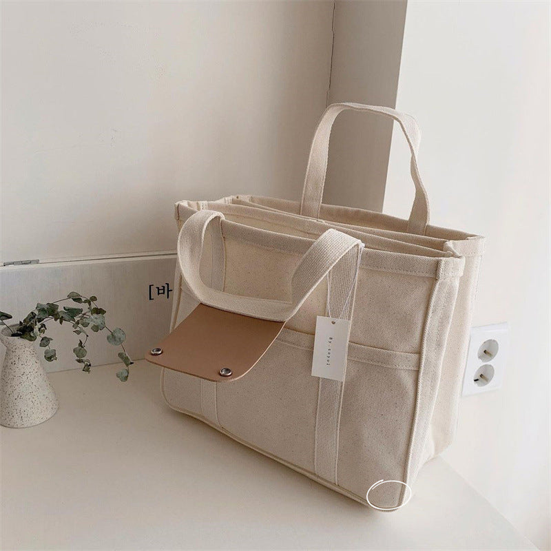 "Enfärgad dam tygkasse i robust canvas, med breda handtag och stor kapacitet. Perfekt som chic och hållbar väska."