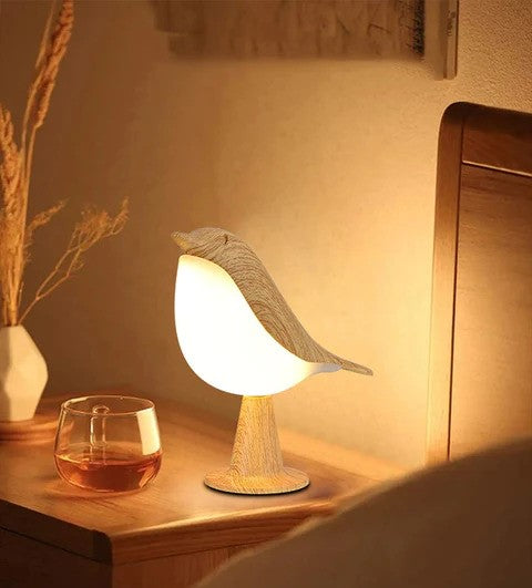 Närbild på fågelformad LED-bordlampa med stämningsfullt ljus och doftspridare