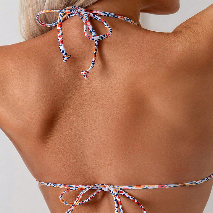 Elegant damtriangelbikini, blommig mönster, justerbara band, idealisk för strandmode.