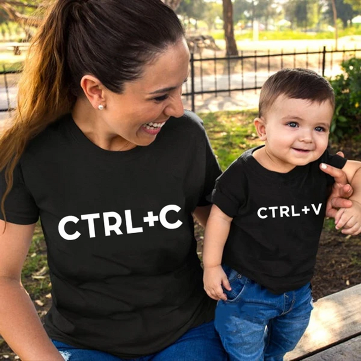 "Familj klädd i matchande vita T-shirts och bodys för barn och vuxna, visande en enhetlig och kärleksfull design."