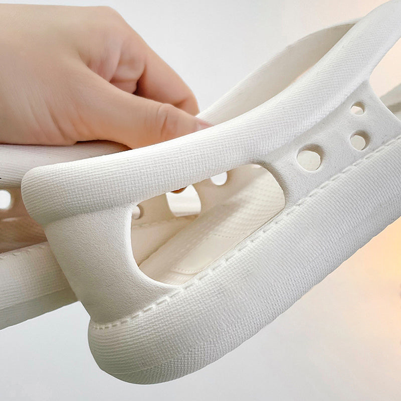 En fot i en vit halkfri sandal som visar dess stilrena design.