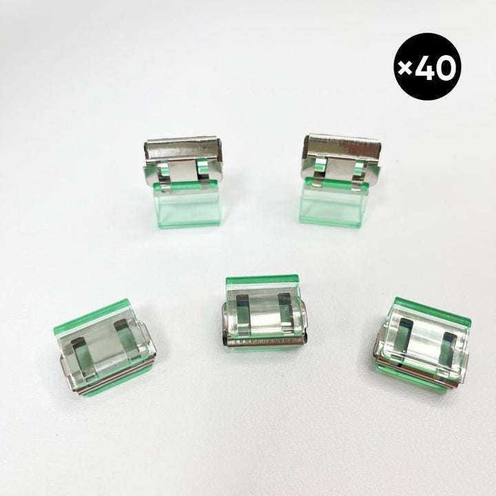Färgglada metallpappersklämmor i grönt, gult, lila, rosa, transparent och blått, perfekt för kontor och skola.