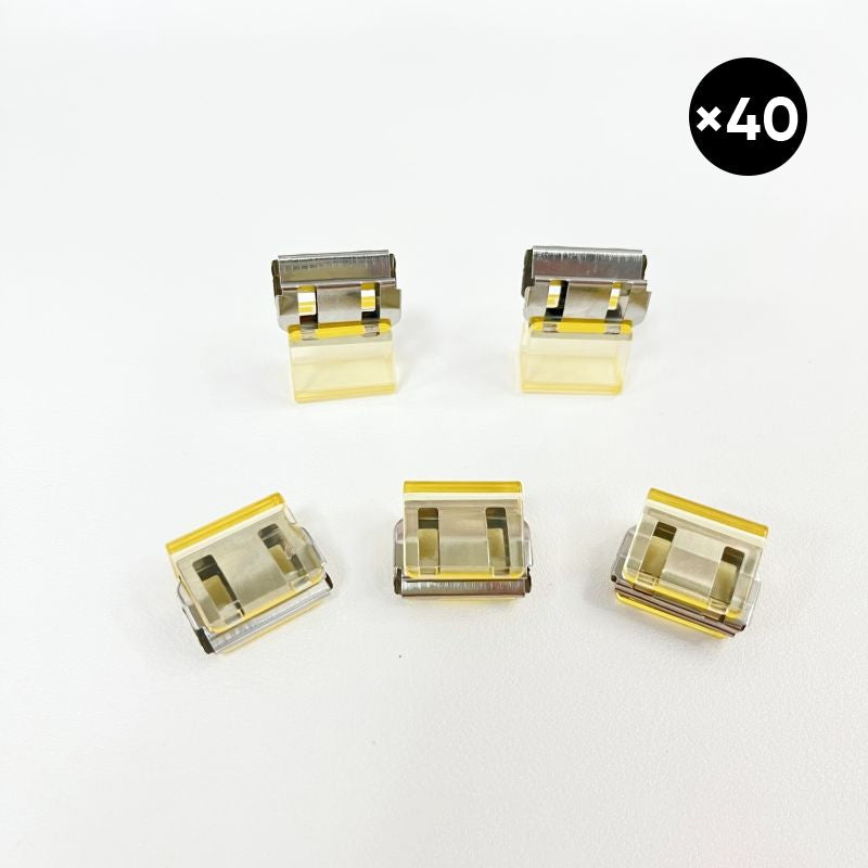 Färgglada metallpappersklämmor i grönt, gult, lila, rosa, transparent och blått, perfekt för kontor och skola.