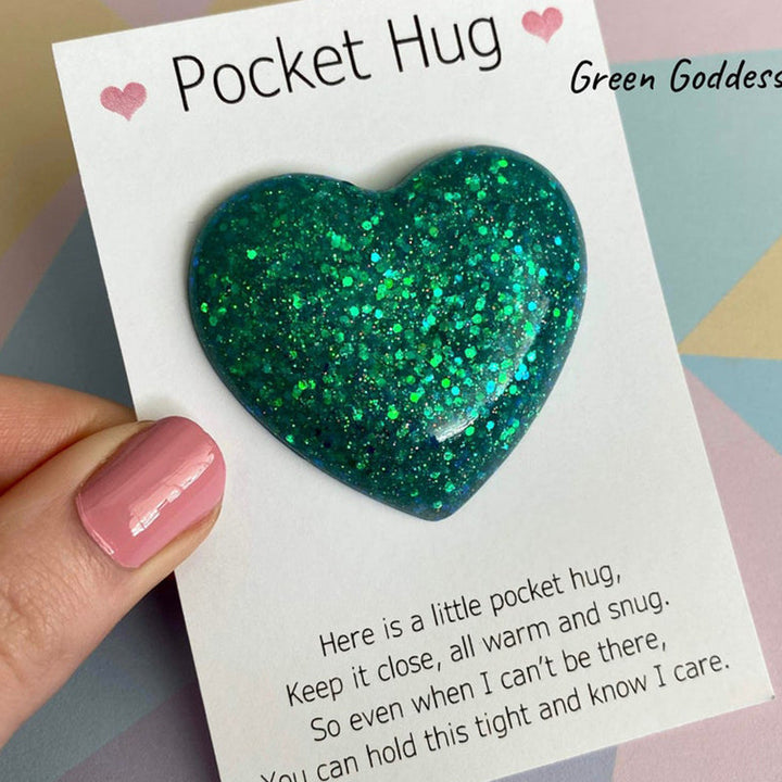 "Färgglatt hjärta i harts, fickvänlig accessoar med kärleksfullt budskap i olika nyanser: guld, blå, lila, grön."