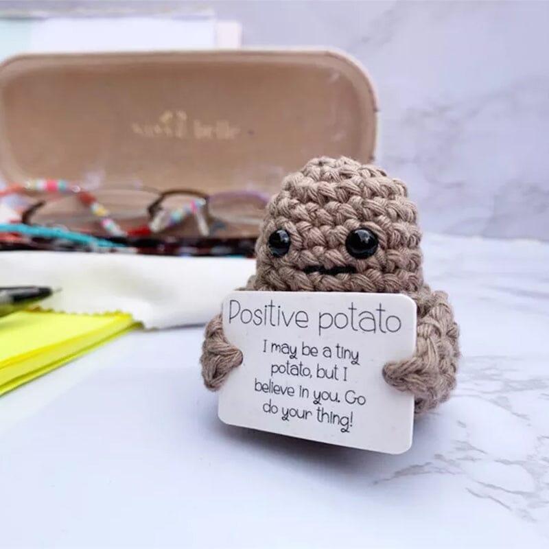 Färgglad stickad positiv potatisdocka med uttrycksfulla detaljer, en rolig julklapp.