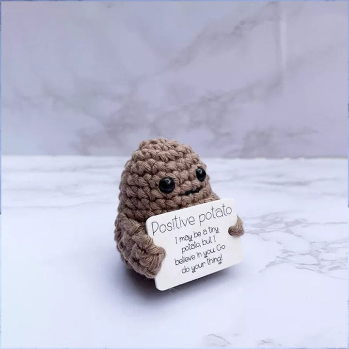 Färgglad stickad positiv potatisdocka med uttrycksfulla detaljer, en rolig julklapp.