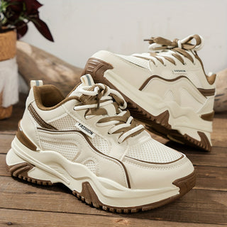 Två ljusbruna chunky plattform sneakers uppställda på trägolv