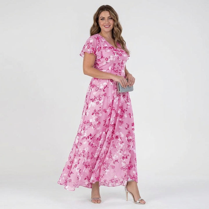 Elegant damklänning i rosa mönstrat tyg med böljande silhuett