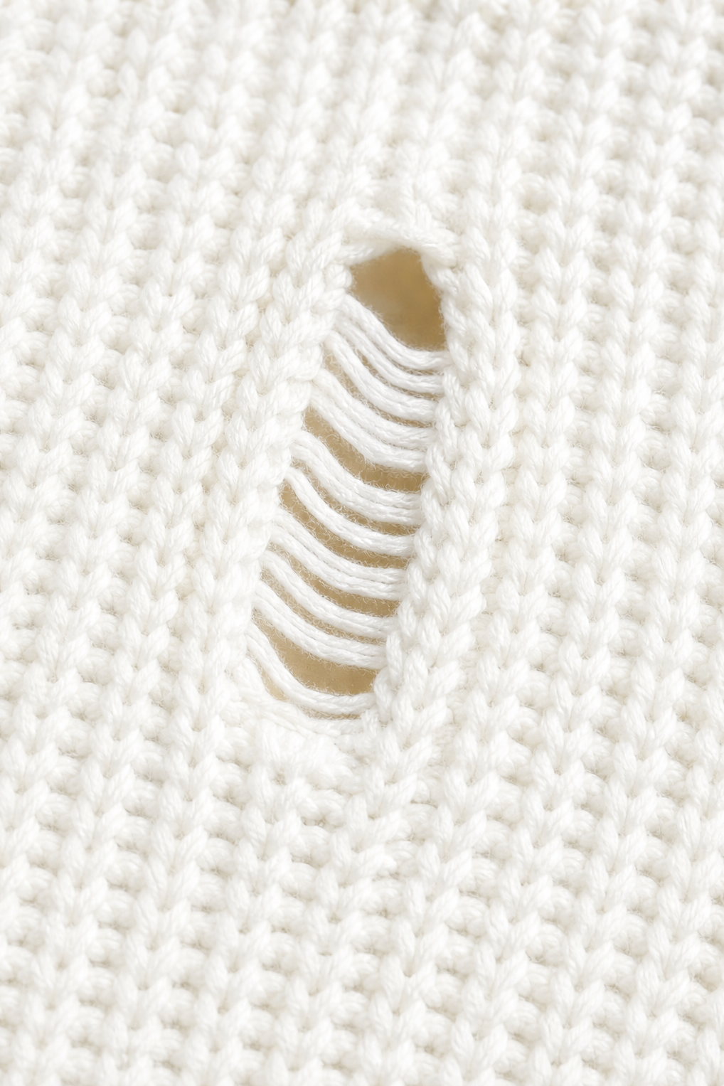 Trendig oversize damtröja i stickat material med slitna inslag