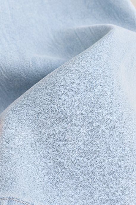 Knappdetalj på stilsäker oversize chambray-skjorta för dam