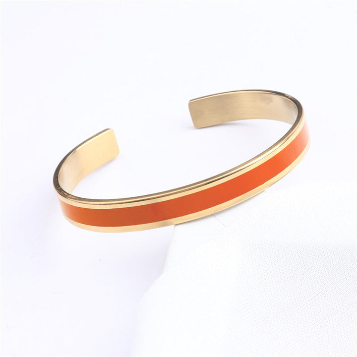 "Flerfärgat damarmband i robust stål med justerbar passform och livfulla orange, gula, blå, rosa, röda och svarta färger."