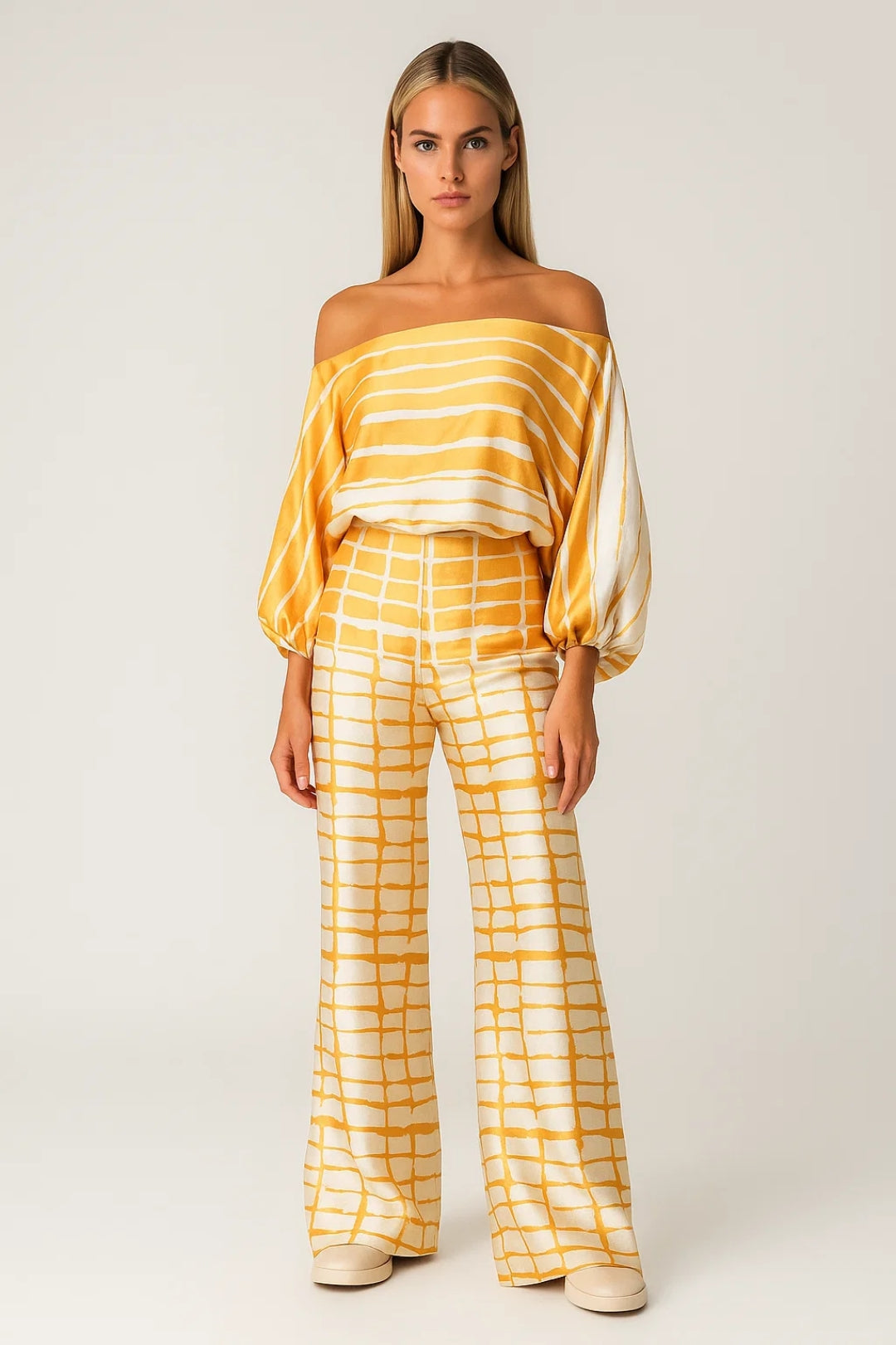 Modell bär gult tvådelat damset med off shoulder och vida byxor