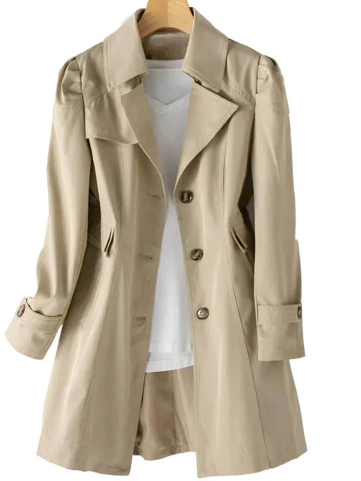 Lång beige trenchcoat för dam med klassisk krage och skärp i midjan, perfekt vårjacka