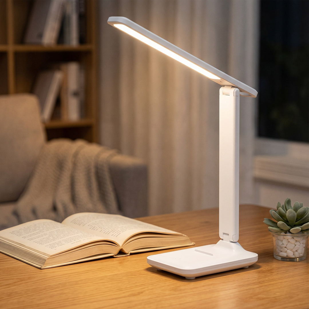 Zvarelo vikbar skrivbordslampa som lyser upp en bok på ett träbord