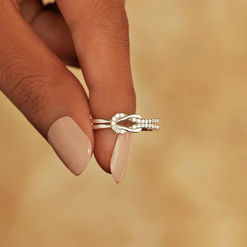 "Glänsande länkad ring i silver och roseguld, symbol för evigt band. Elegant, tidlös design, perfekt accessoar."