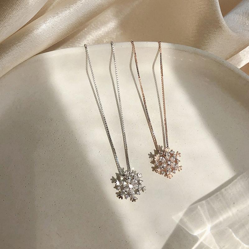 "Glänsande snöflinga halsband för damer i zirkon, justerbar längd, roséguld och silver, elegant och tidlös design."
