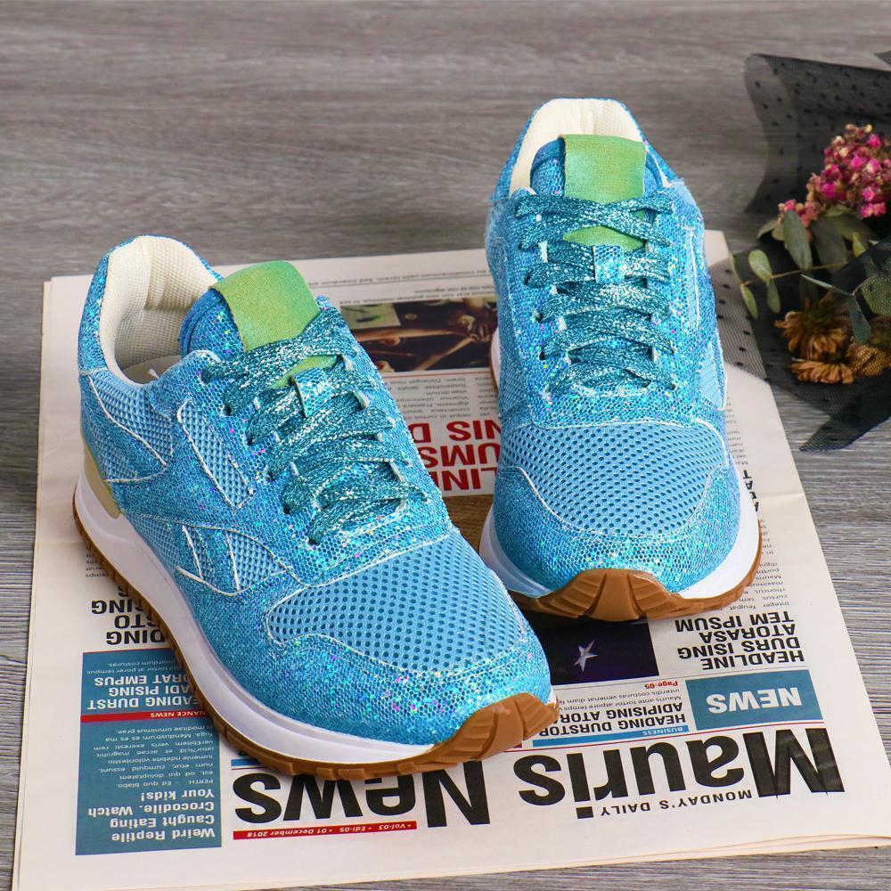 Gnistrande damsneakers med kristaller i blå, rosa och vit, elegant designad för stil och komfort.