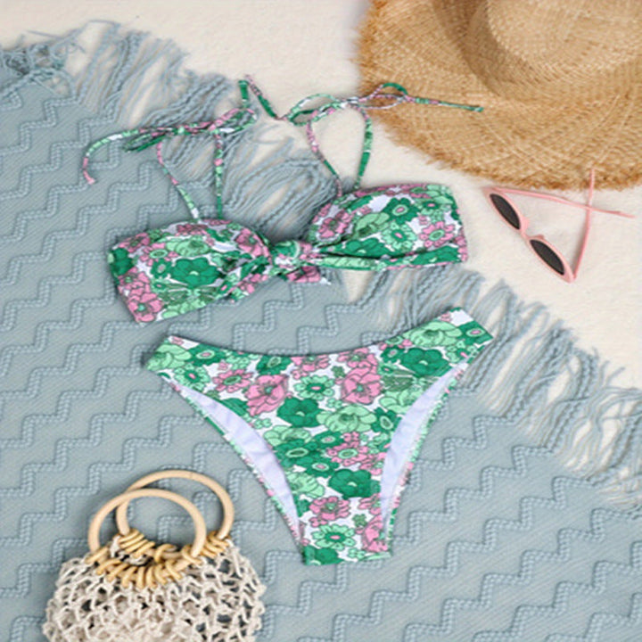 Trendig damtriangelbikini i grön nyans med blommönster och lekfull knut. Idealisk för sommarstil.