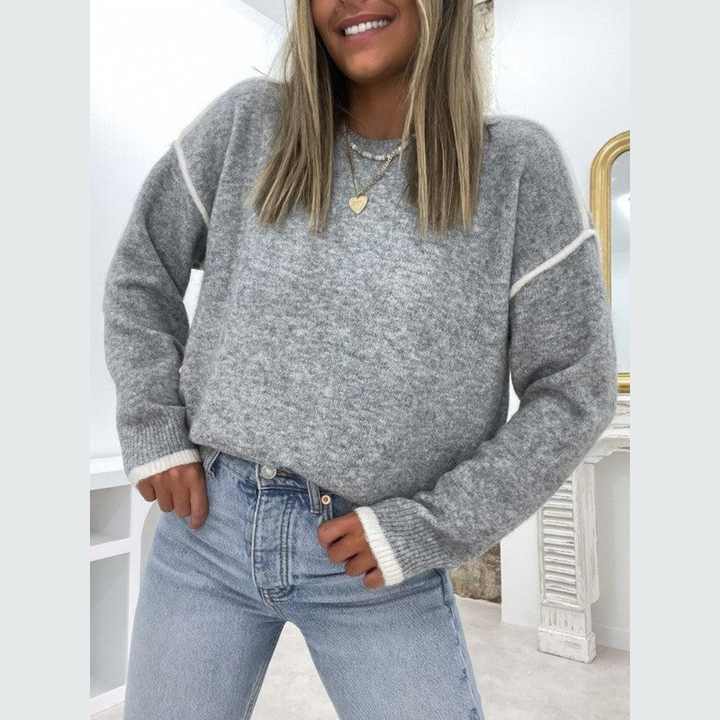Grå, stickad damtröja med rund halsringning, perfekt för höst och vinter. Bekväm och tidlös pullover.