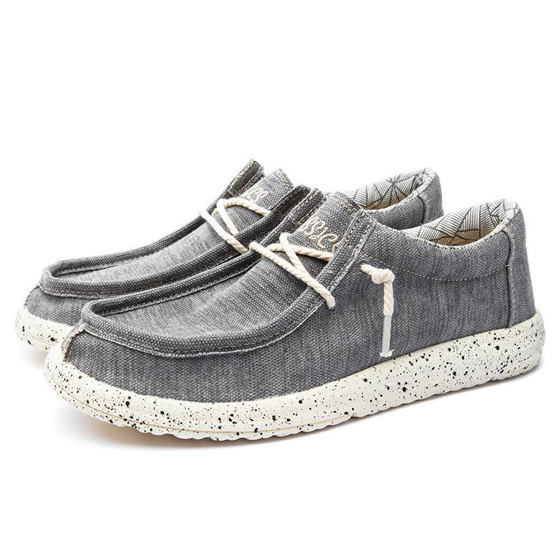 Herr canvas skor i grått med slip-on design, bekväm passform och maskintvättbara. Perfekta för vardagligt bruk.