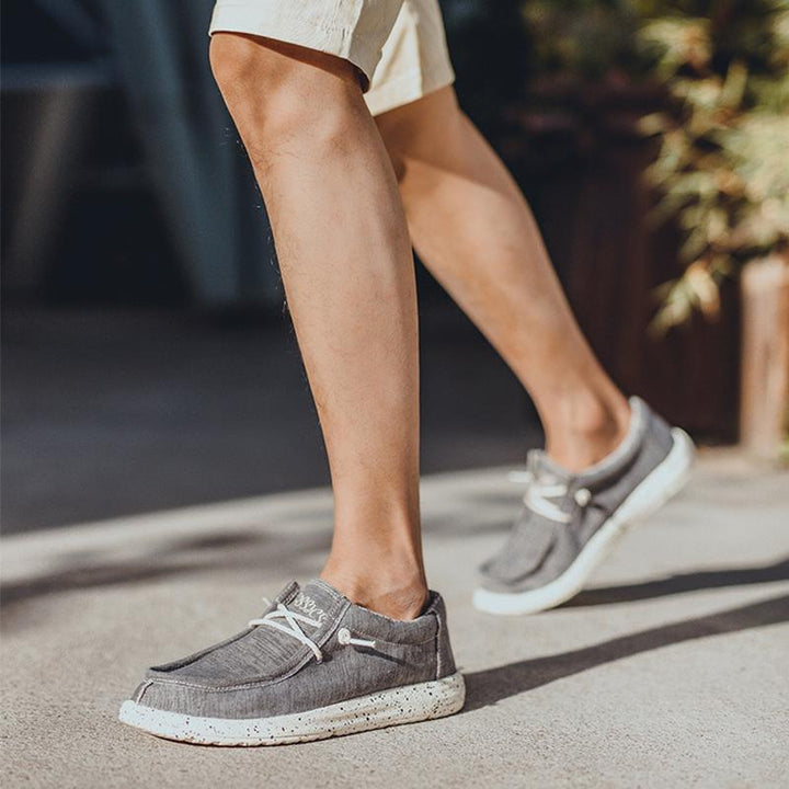 Herr canvas skor i grått med slip-on design, bekväm passform och maskintvättbara. Perfekta för vardagligt bruk.
