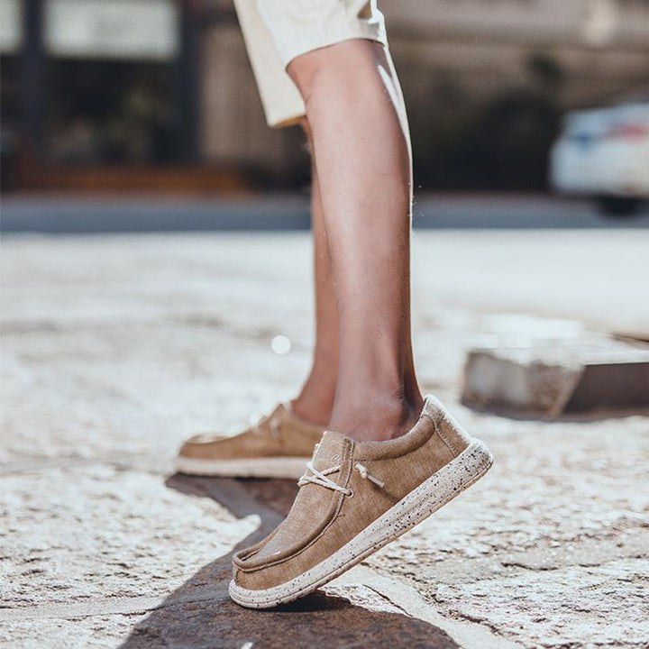 Herr canvas skor i grått med slip-on design, bekväm passform och maskintvättbara. Perfekta för vardagligt bruk.