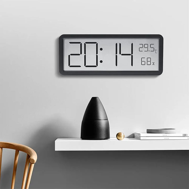 Närbild på svart digital väggklocka med tid och temperatur