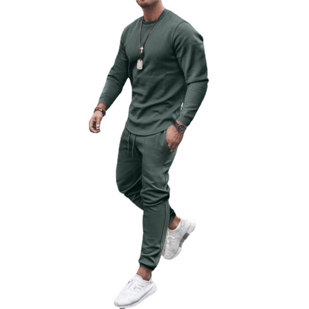 Grön joggingdräkt för herrar mot vit bakgrund