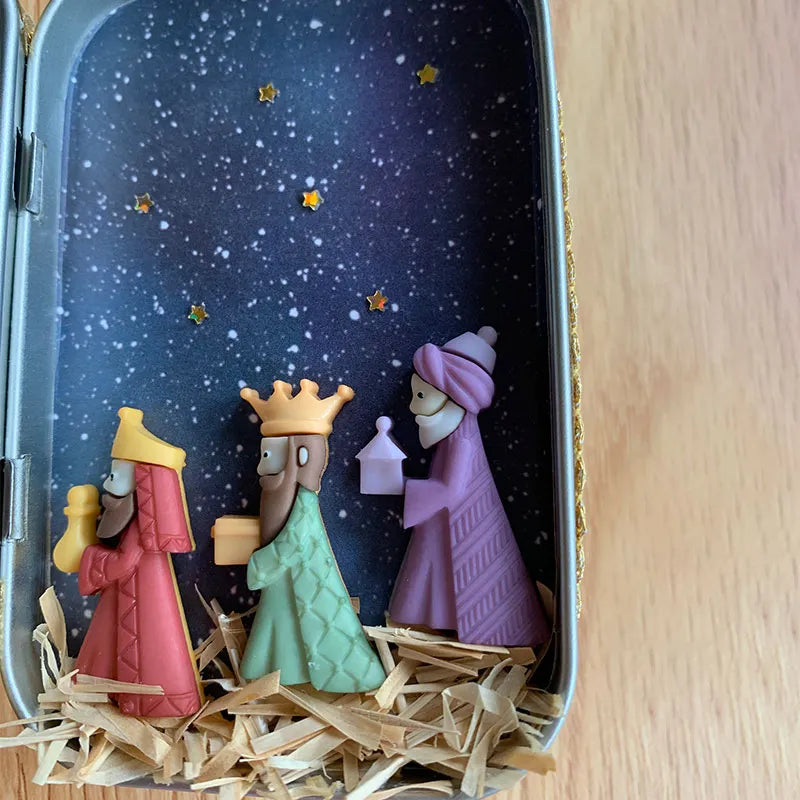 "Handgjord julkrubba med figurer som Maria, Josef, Jesus under stjärnklar natt, perfekt för festlig dekoration."