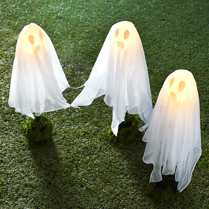 "Hängande LED-ljus spöke för Halloween, vitt tyg och glödande ansikte, perfekt för utomhusdekorationer."