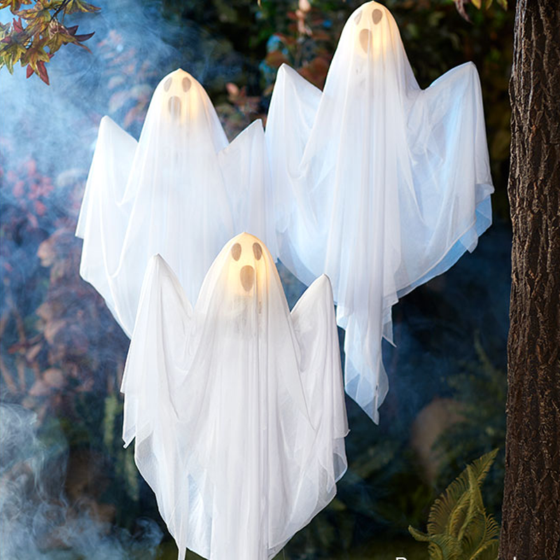"Hängande LED-ljus spöke för Halloween, vitt tyg och glödande ansikte, perfekt för utomhusdekorationer."