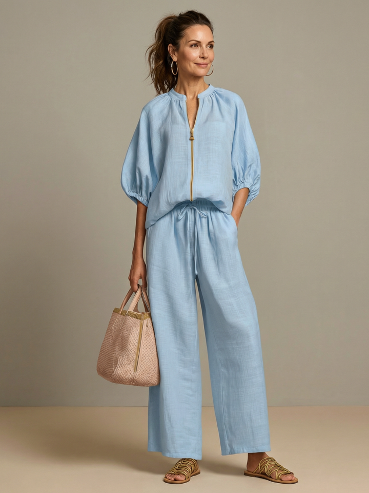Modell i himmelsblått damset med ballongärmar och vida byxor