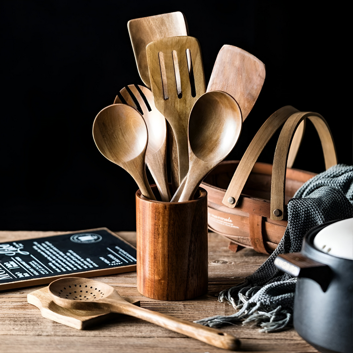 Set med olika träredskap i teak, inklusive spatel och slev, för varierad matlagning i köket.