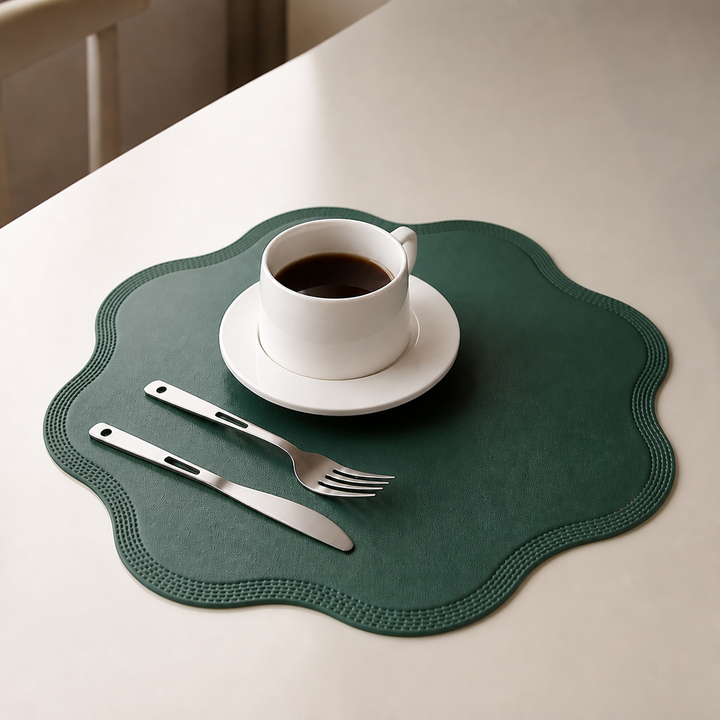 Närbild på ett grönt runt Wearbella bordsunderlägg med vit kaffekopp och bestick