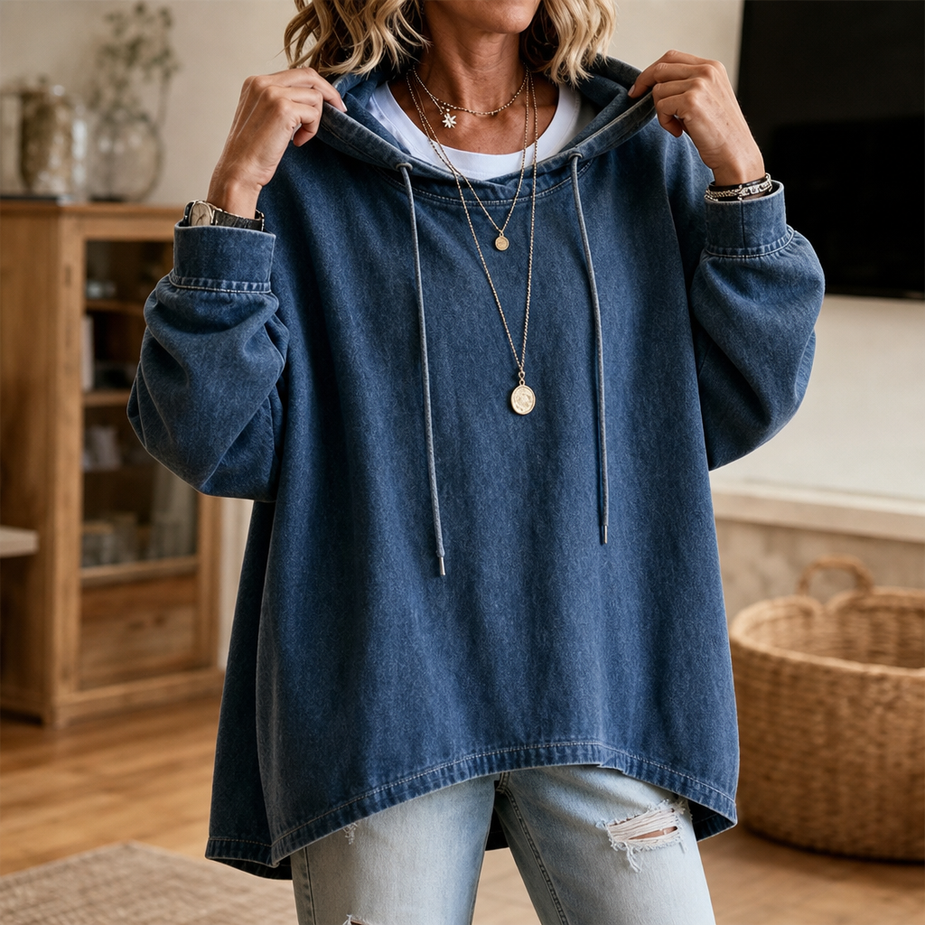 Kvinna i blå denimhuvtröja som poserar inomhus