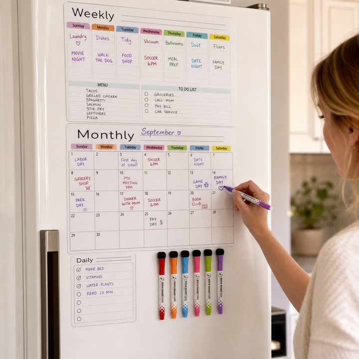 Kvinna som skriver på en magnetisk kylskåpskalender med färgade pennor