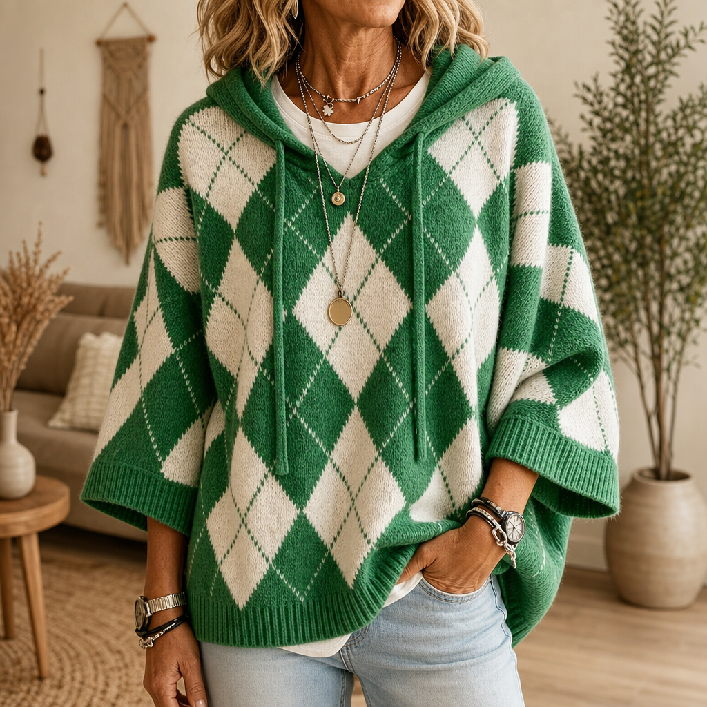 Kvinna i grön argyle-ponchotröja med huva och jeans