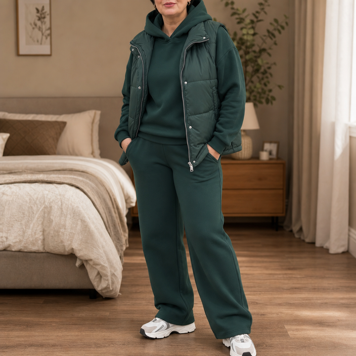 Kvinna i grönt damset med hoodie, träningsbyxor och väst