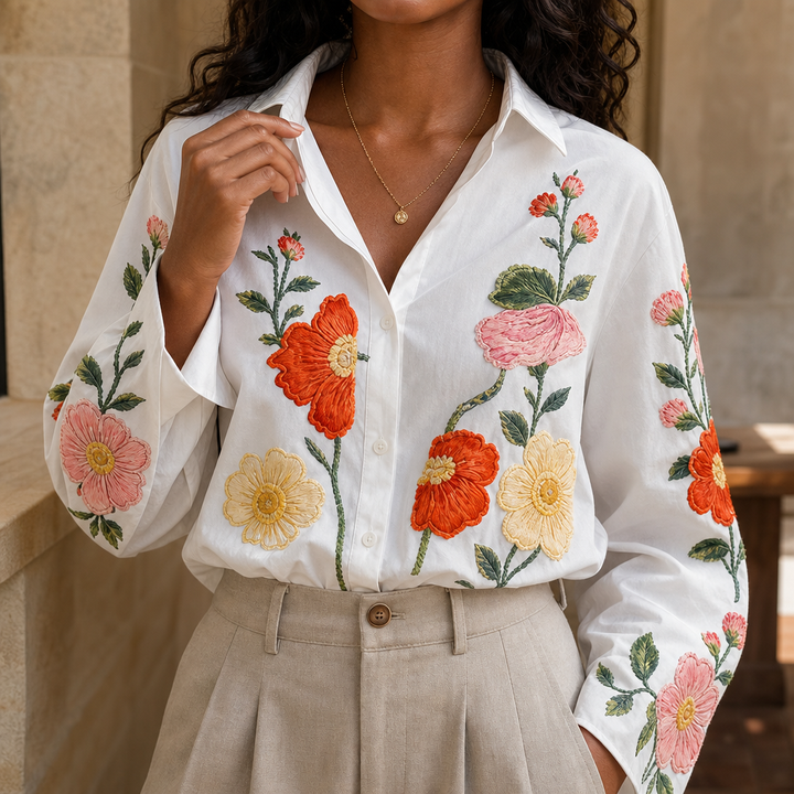Vit damblus med broderat blomönster och krage framifrån