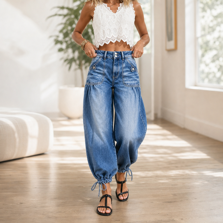 Närbild på damens blå barrel-jeans med fickor framifrån i ljus miljö