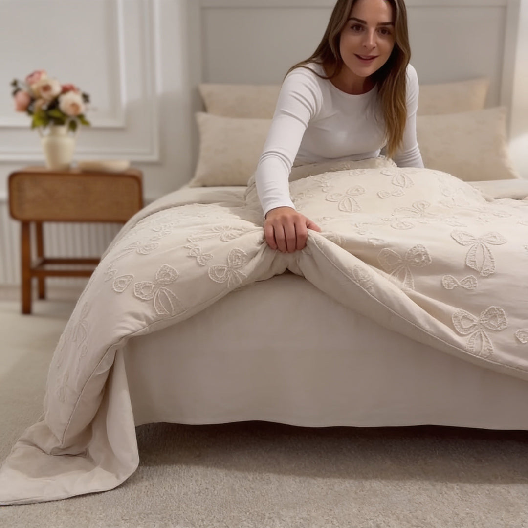 Kvinna bäddar sängen med ett elegant tuftat påslakan