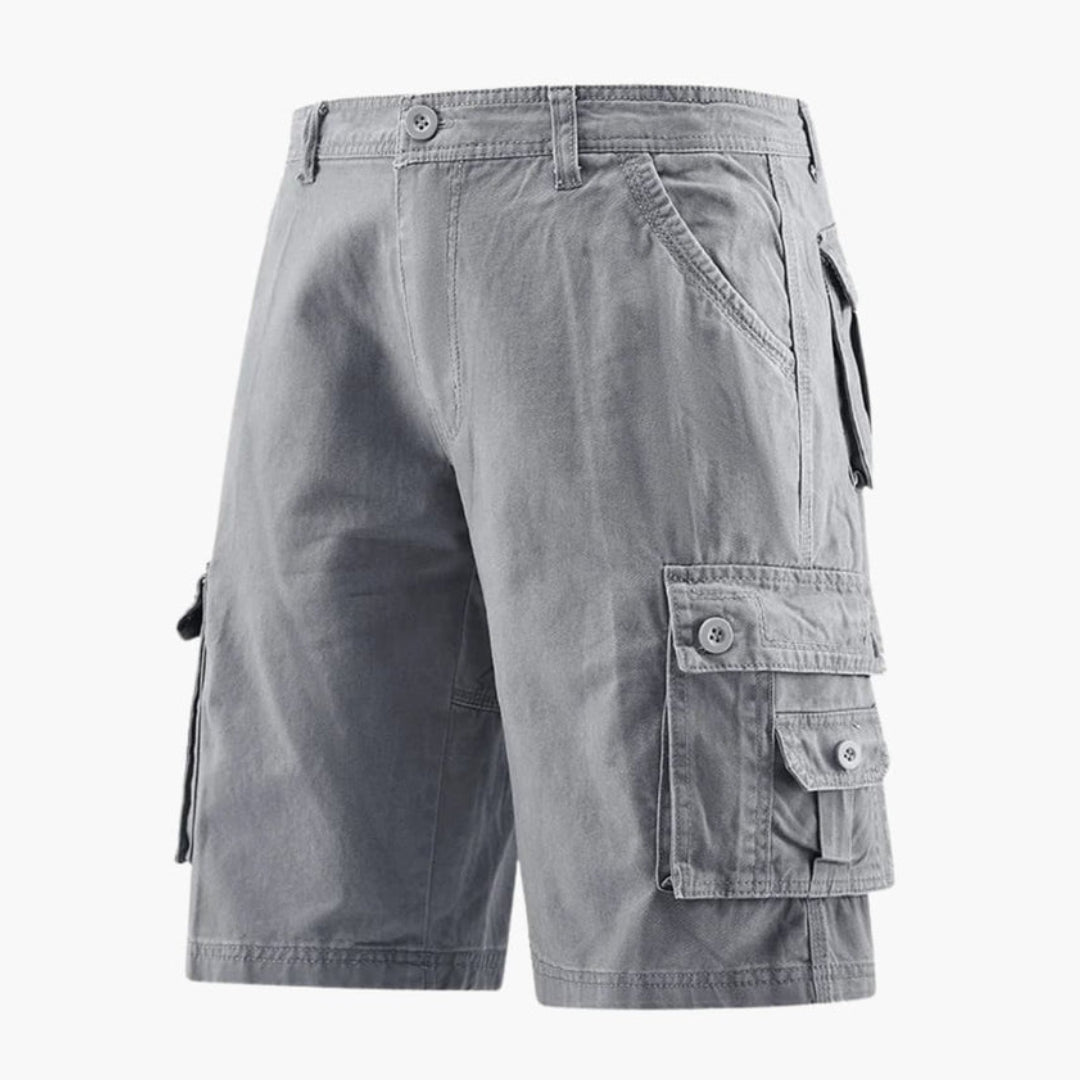 Man bär ljusgrå cargoshorts utomhus, visar en bekväm och stilren fritidslook för sommaren.