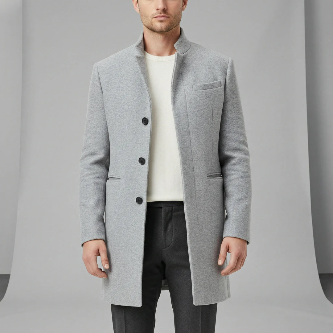 Detaljbild av elegant minimalistisk långkappa. Högkvalitativt tyg, enkelknäppt för herrmode & formell stil.