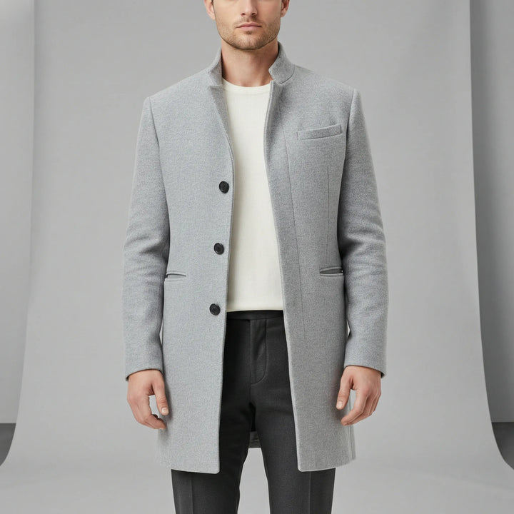Detaljbild av elegant minimalistisk långkappa. Högkvalitativt tyg, enkelknäppt för herrmode & formell stil.